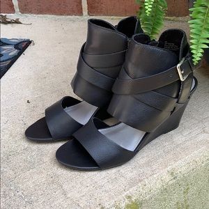 Black leather sandals with wedge heel.